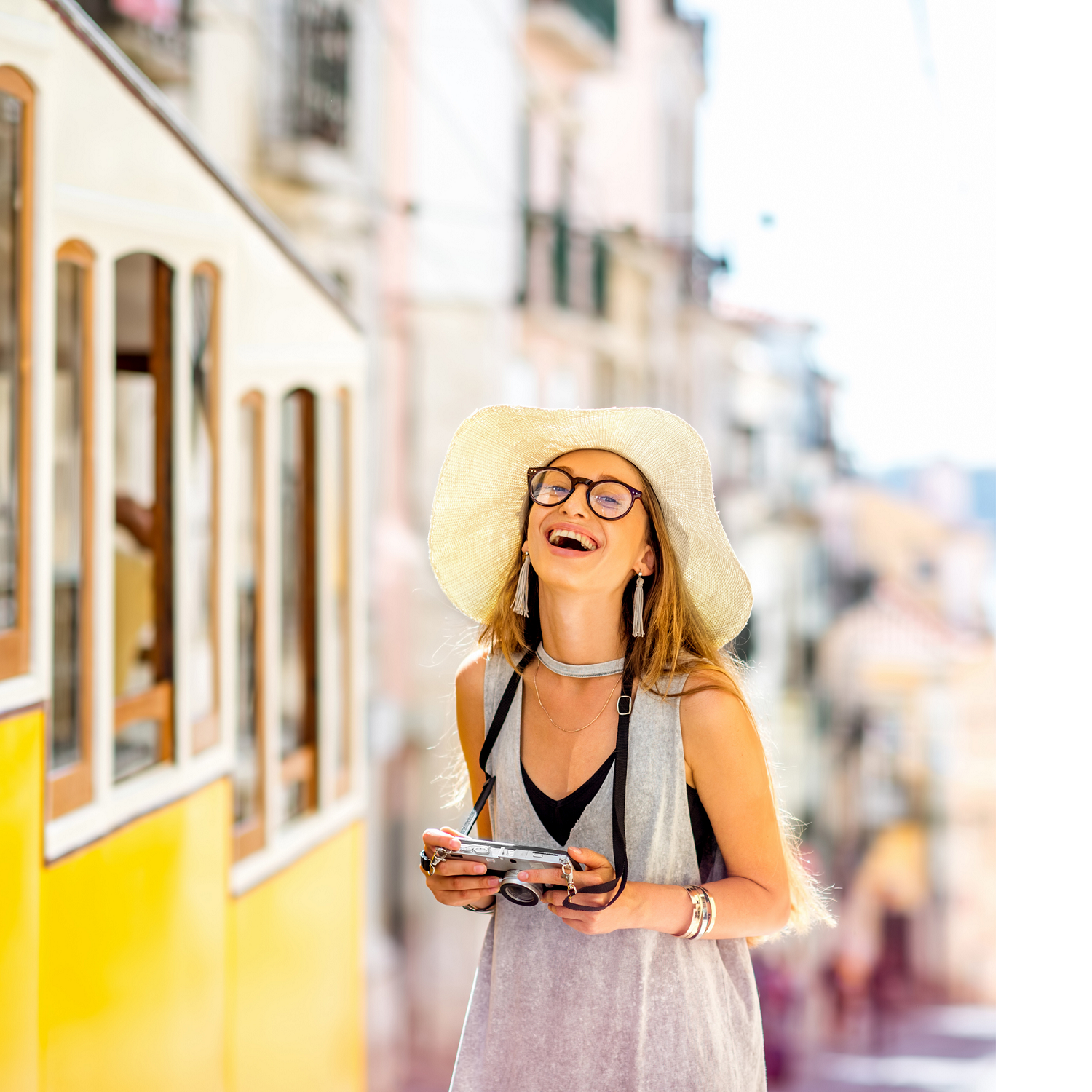 Woman with hat & glasses getting onboard a yellow tram